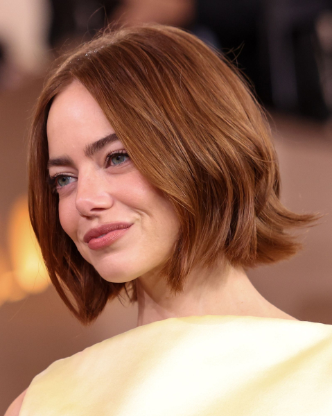 Emma Stone posing in a yellow dress